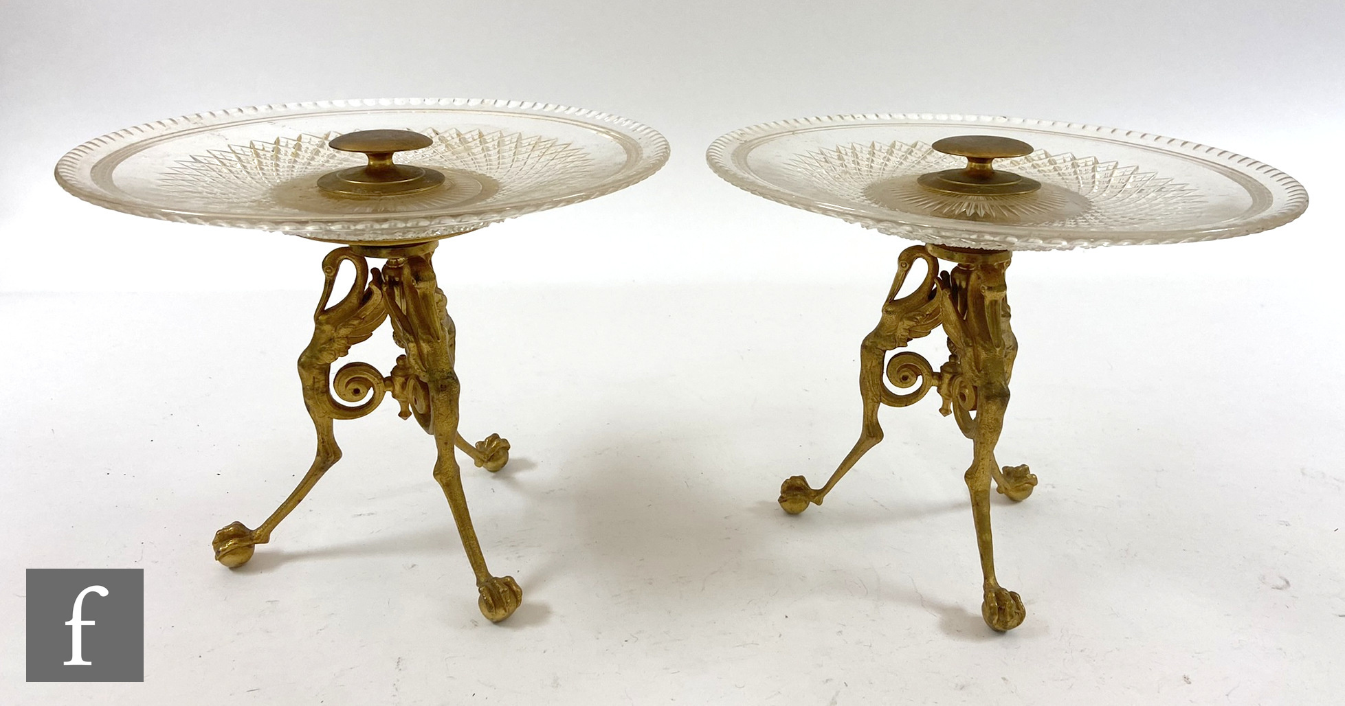 A pair of early 20th Century tazzas with cut glass dishes raised on tripod ormolu bases, height