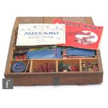 A collection of assorted Meccano pieces including blue and gold and red and green, with instructions