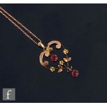 An early 20th Century 9ct red stone set rose gold open work pendant suspended from a fine trace