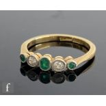 An early 20th Century emerald and diamond five stone ring, alternating millgrain set stones to knife