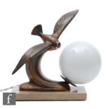 A 20th Century French patinated spelter table lamp, decorated with a bird in flight over a