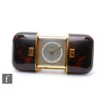 A 1950s Europa travel alarm clock in a faux tortoiseshell and gilt cushion metal case, width 8cm