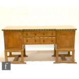 An early 20th Century light oak break-fronted sideboard by Heal and Son Ltd, with hand painted