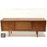 A post war Danish teak sideboard designed by Johannes Andersen, fitted with a central bank of four