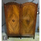 An early 20th Century mahogany two door wardrobe, the hanging space enclosed by a pair of doors each