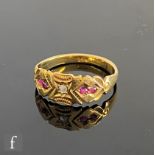An early 20th Century 18ct ruby and diamond boat shaped ring, central diamond flanked by two