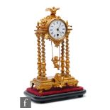 A 19th Century French gilt portico clock, the white dial surmounted with a bird above a swinging
