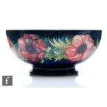 A Moorcroft footed bowl decorated in the Anemone pattern with tubelined flowers to the exterior