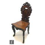 A 19th Century Black Forest marquetry inlaid hall chair, the pierced balloon shaped back inlaid with
