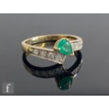 A 9ct hallmarked emerald and diamond ring, central pear shaped, claw set emerald to diamond set