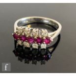 An 18ct hallmarked white gold ruby and diamond ring, five rubies flanked above and below by eight