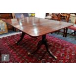 A 19th Century mahogany twin pedestal extending dining table with central leaf, rounded ends on