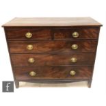 A George III mahogany straight front chest of two short and three long crossbanded drawers, oval