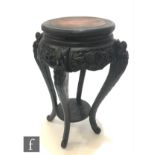 A Chinese carved wooden jardiniere stand, the circular top with four carved tapered supports, united