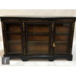 A Victorian gilt metal mounted and ebonised breakfront credenza, the shelf interior enclosed by