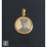 An early 20th Century open circular open locket with a photograph of a soldier to one side and an