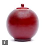 A later 20th Century spherical jar and cover decorated in an all over oxblood flambe red, in the