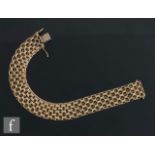 A 9ct flexible bracelet of a pierced black design, weight 26.5g, length 21cm, terminating in