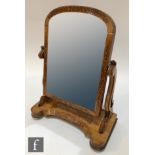 A Victorian marquetry inlaid burr maple arch shaped toilet swing mirror, the plate supported by