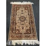 A modern Aubusson style Persian rug central leaf bordered medallion on an ivory and red multi