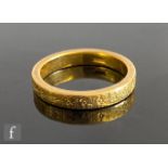 A 22ct wedding ring decorated with engraved flower head details, weight 5.8g, ring size O, stamped