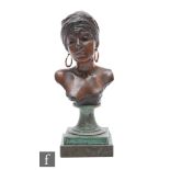 A bronze bust of a female figure wearing a headscarf and earrings, to a square sectioned base,