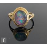 A 9ct hallmarked oval opal doublet single stone ring, collar set within a rope twist border and