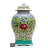 A Chinese famille rose jar and cover, of baluster form surmounted by a domed rim cover, the body