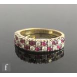 An 18ct hallmarked ruby and diamond double half eternity ring with two rows of alternating stones,