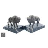 A pair of 20th Century bronze bookends, modelled as a stylised buffalo, mounted to an angled black