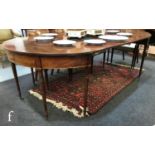 A George III extending mahogany oval dining table, the reeded edge top over a line inlaid plain