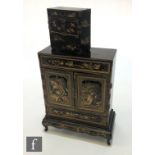 A late 19th Century Japanese black chinoiserie lacquered table cabinet on stand, the centre