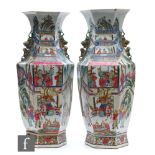 A pair of Chinese 19th Century Canton famille rose vases, each of hexagonal form, rising from a high