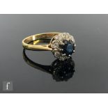 An 18ct sapphire and diamond cluster ring, central circular sapphire within a border of eight