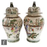 A pair of Chinese porcelain famille rose vases and covers, each of ovoid form, surmounted by a domed