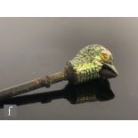 An early 20th Century model of the head of a bird with remains of green and yellow enamel