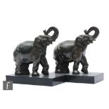 A pair of 20th Century spelter bookends decorated with stylised elephants mounted to a rectangular