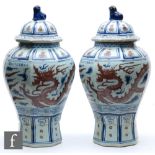 A pair of Chinese vases and covers, each of meiping form, surmounted by a domed cover with shishi