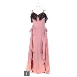 A 1950s ladies vintage evening dress in pink satin, the bodice with a black lace and sequined collar