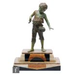 A 20th Century green painted spelter study depicting a boy fishing, mounted on a stepped Art Deco