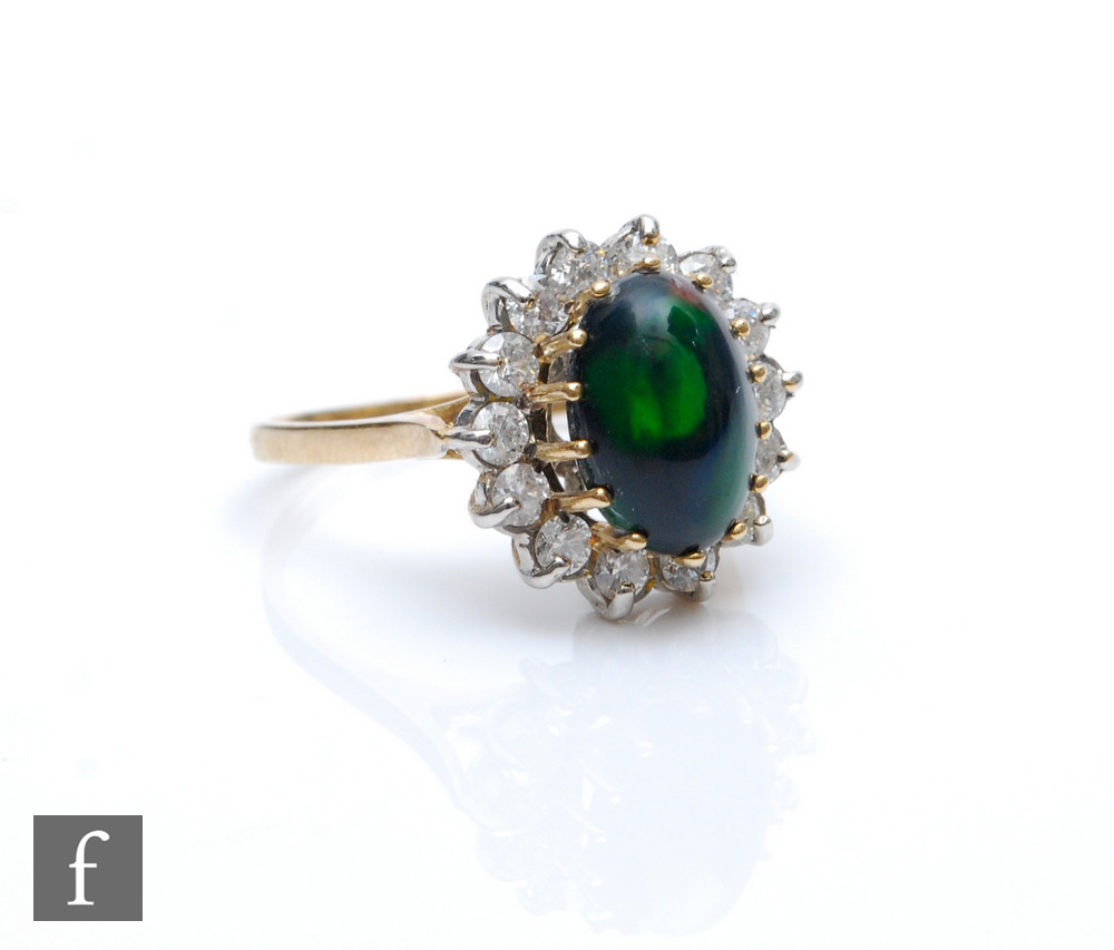 A 9ct hallmarked black opal and diamond cluster ring, central oval opal, length 11mm, within a