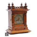 A late 19th Century walnut cased mantle clock with eight day movement, the silvered Arabic dial