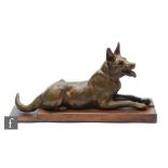 A 20th Century patinated spelter study depicting a recumbent Alsatian, mounted to a rectangular