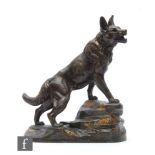 A 20th Century patinated spelter figure after L. Carvin, modelled as an Alsatian standing on a rocky