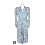 A late 1940s ladies vintage dress in light blue with black and white floral pattern, with pleated