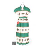 A 1950s ladies vintage dress in cream cotton with printed banded Aztec pattern in green yellow and