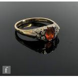 A 9ct hallmarked fire opal and diamond cluster ring, central opal flanked by three diamond to either