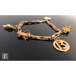 An early 20th Century 9ct rose gold fancy dog link bracelet with four charms attached, total