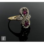 An 18ct hallmarked ruby and diamond ring modelled as a figure of eight with two central rubies and