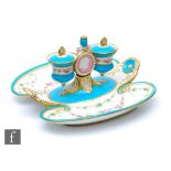 A 19th Century Minton desk stand with twin inkwells flanking a pink medallion, raised to a shaped